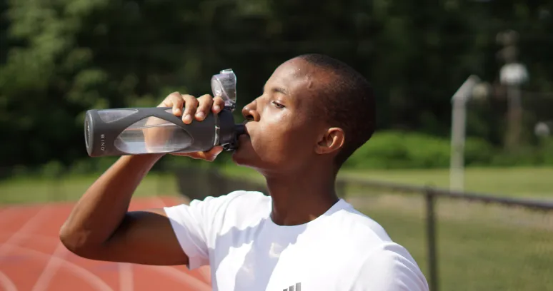 Person drinking water during 18:6 intermittent fasting to stay hydrated during extended fasting period